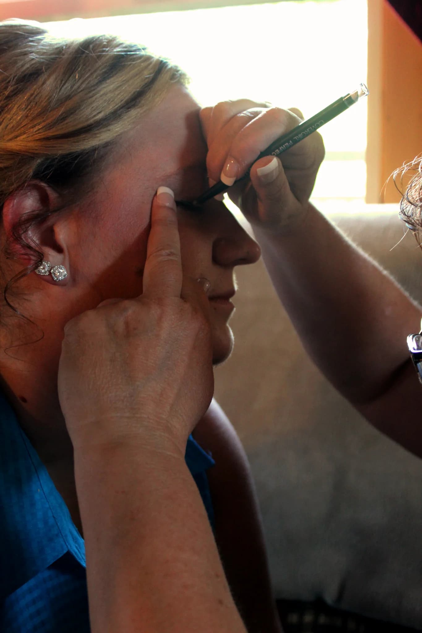 Bride receiving professional eye makeup application during wedding prep at Moose Hollow Lodge in Pigeon Forge