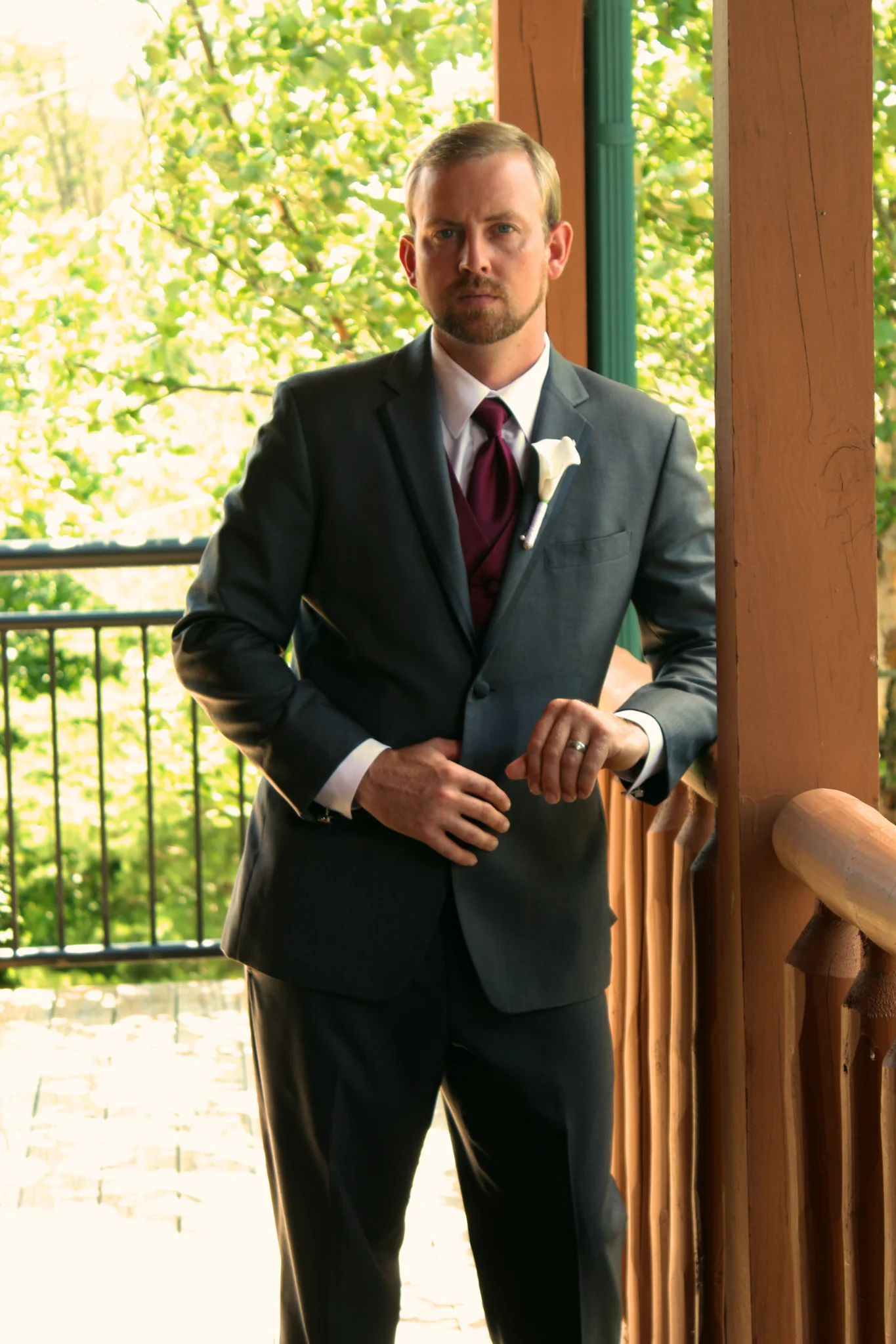 Groom in formal attire on a rustic wooden deck near Dollywood at Moose Hollow Lodge in Pigeon Forge.