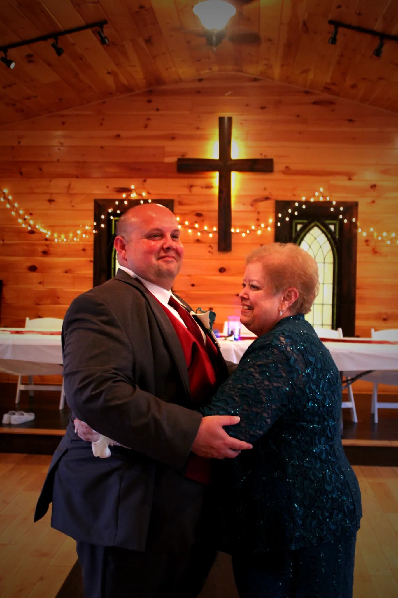 Wedding dance in rustic chapel with wood cross and string lights at Moose Hollow Lodge in Pigeon Forge