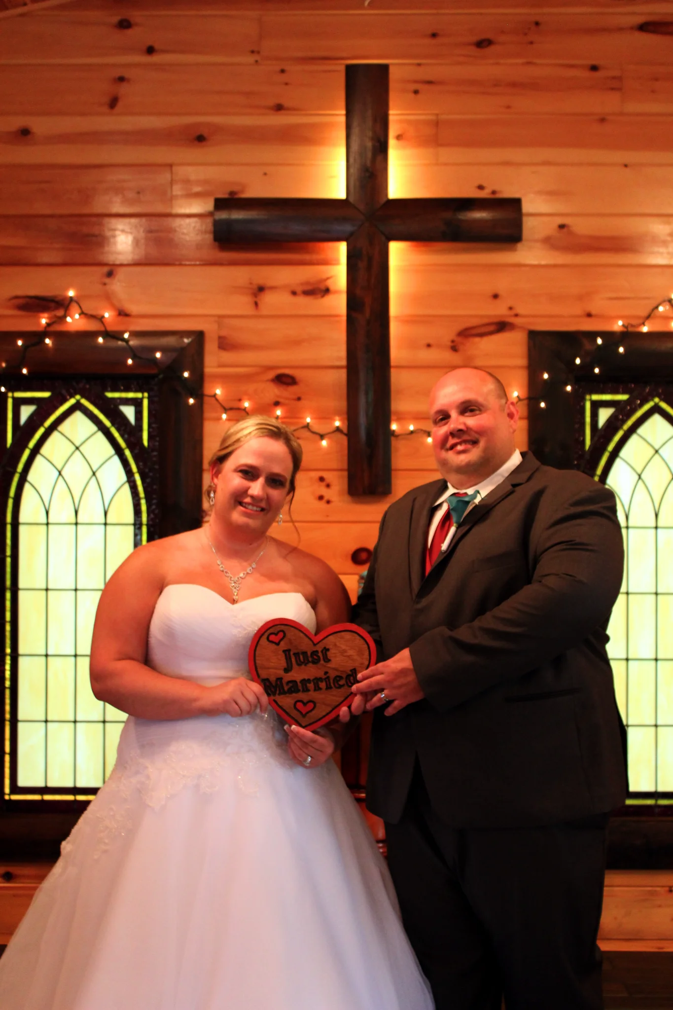 Happy couple with Just Married sign in a rustic chapel at Moose Hollow Lodge in Pigeon Forge