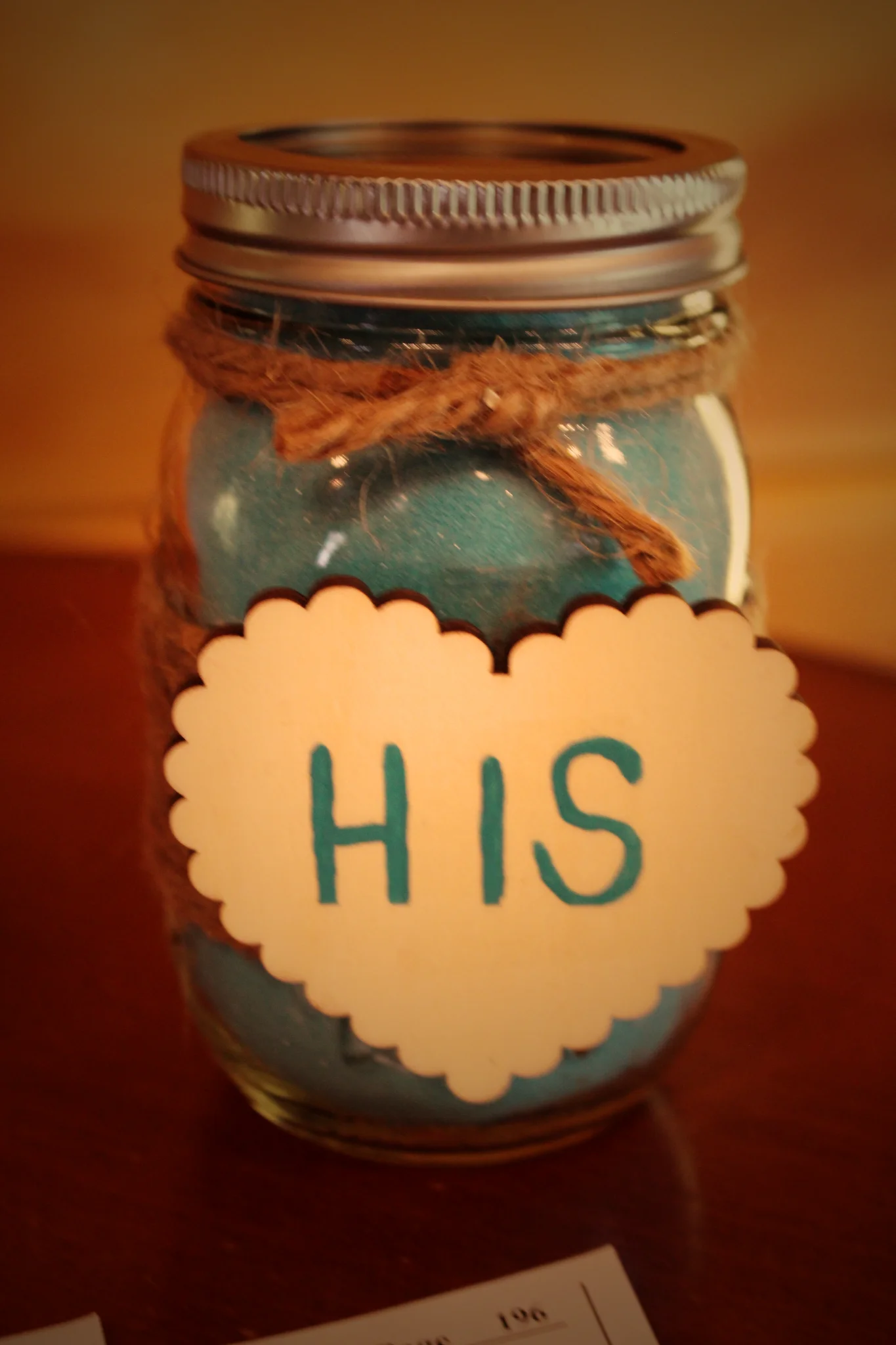 Rustic wedding sand ceremony jar with blue sand and "HIS" heart tag at Moose Hollow Lodge in Pigeon Forge