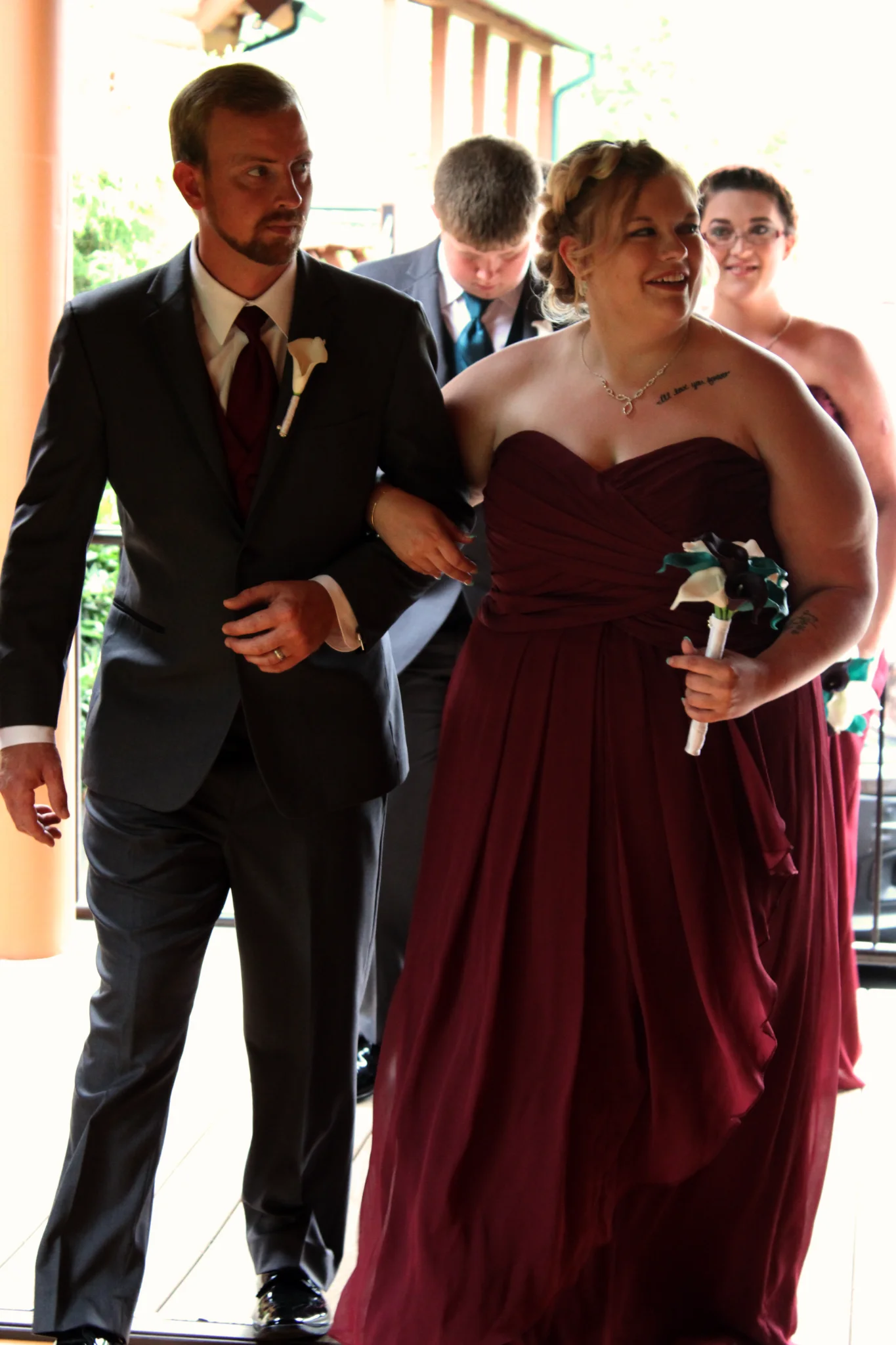 Wedding party in burgundy walking on a deck at Moose Hollow Lodge in Pigeon Forge near the Smoky Mountains