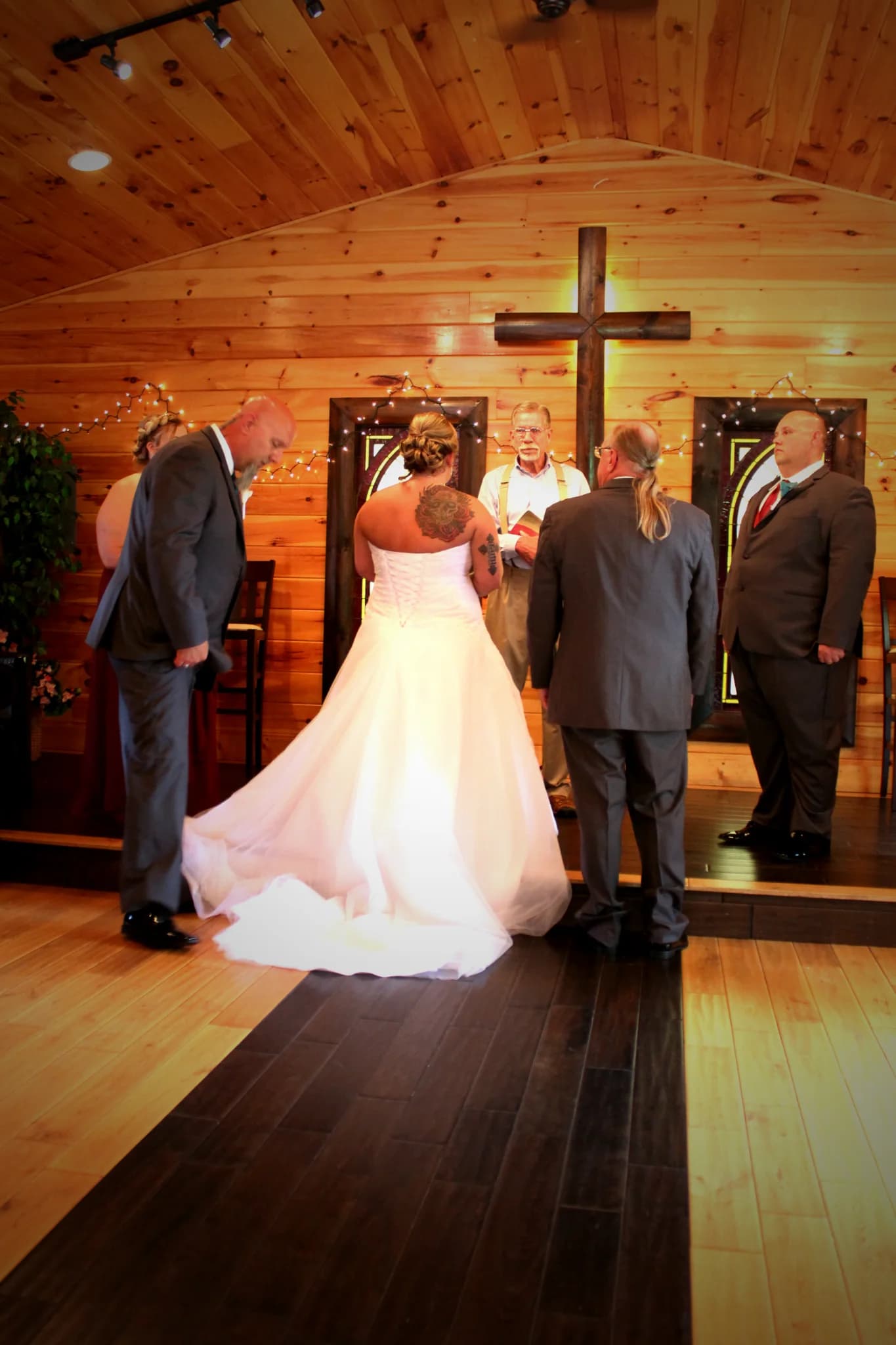 Wedding ceremony in a rustic wood-paneled chapel with a wooden cross at Moose Hollow Lodge in Pigeon Forge