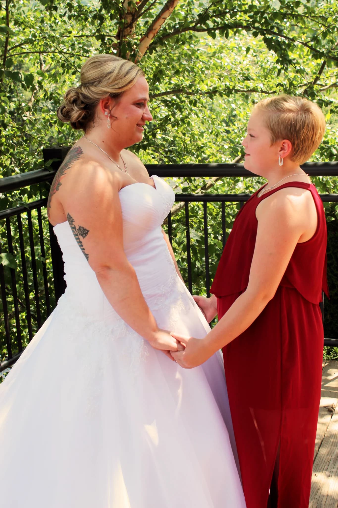 Bride and bridesmaid holding hands on forest deck at Moose Hollow Lodge in Pigeon Forge near Smoky Mountains
