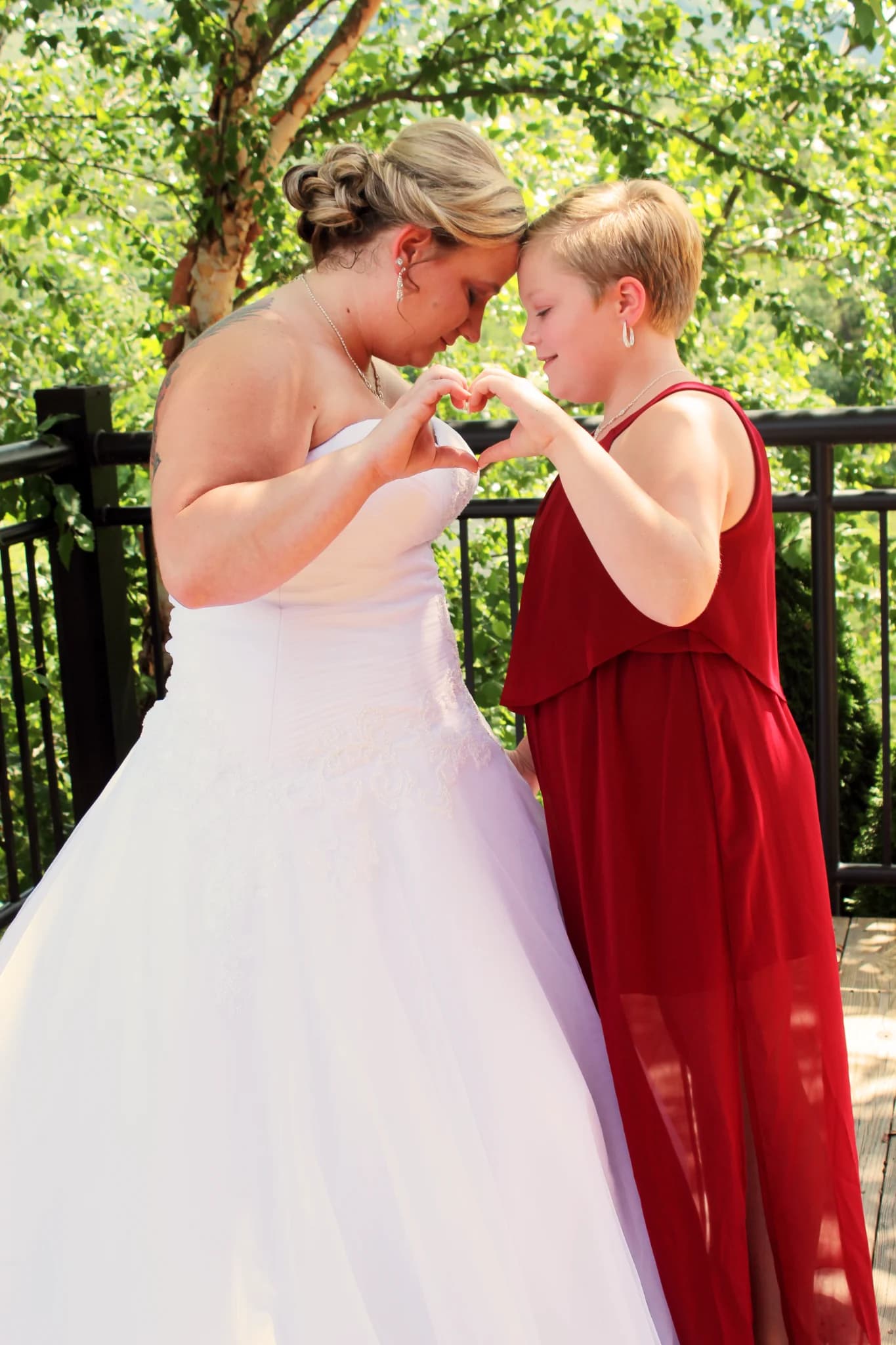 Bride and girl making heart on outdoor deck at Moose Hollow Lodge in Pigeon Forge near the Smoky Mountains