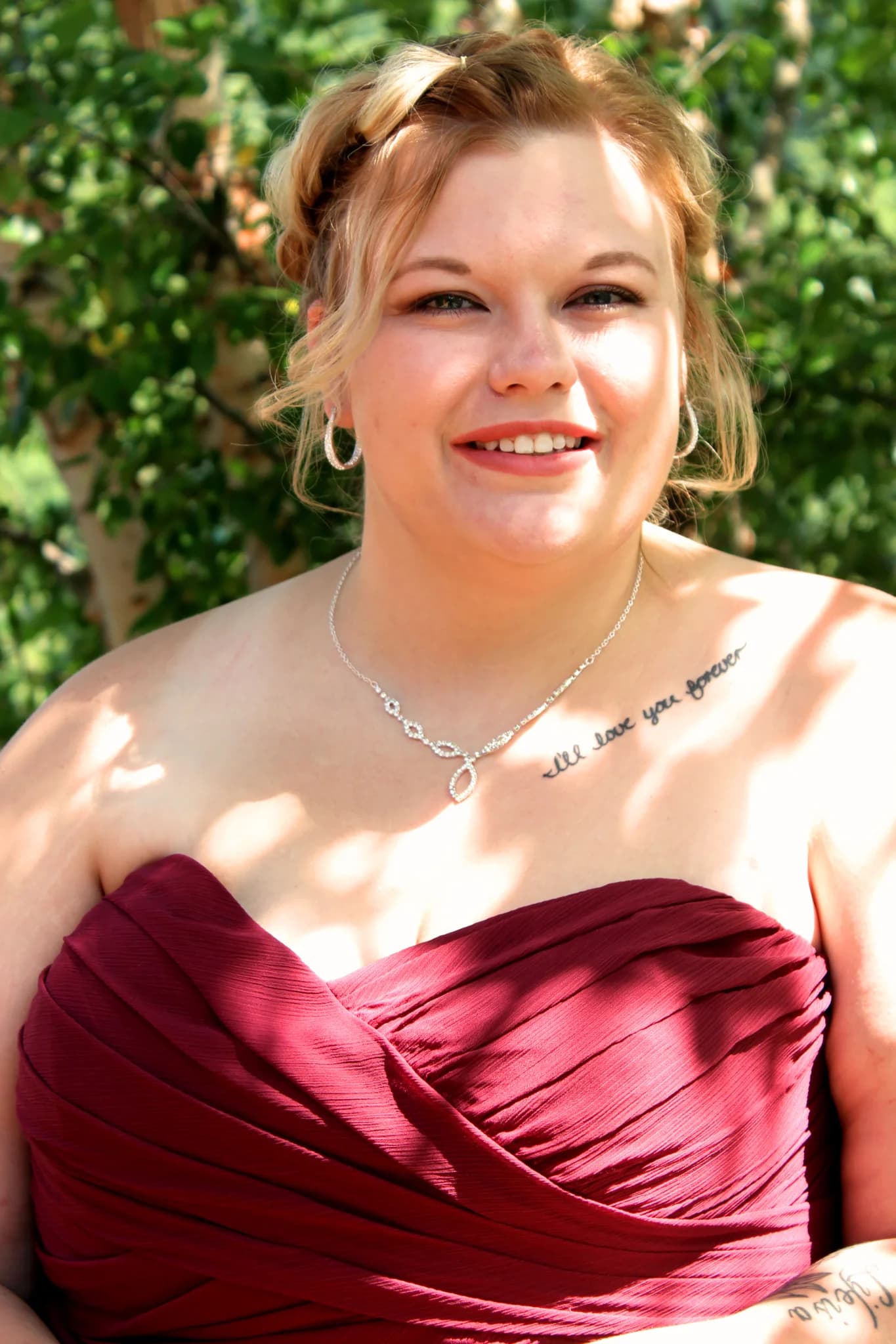 Smiling guest in maroon dress outdoors at Moose Hollow Lodge in Pigeon Forge near Dollywood and Smoky Mountains