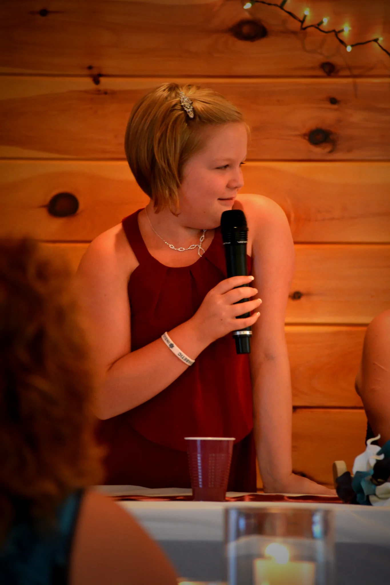 Young guest giving a wedding toast in the rustic reception hall at Moose Hollow Lodge in Pigeon Forge