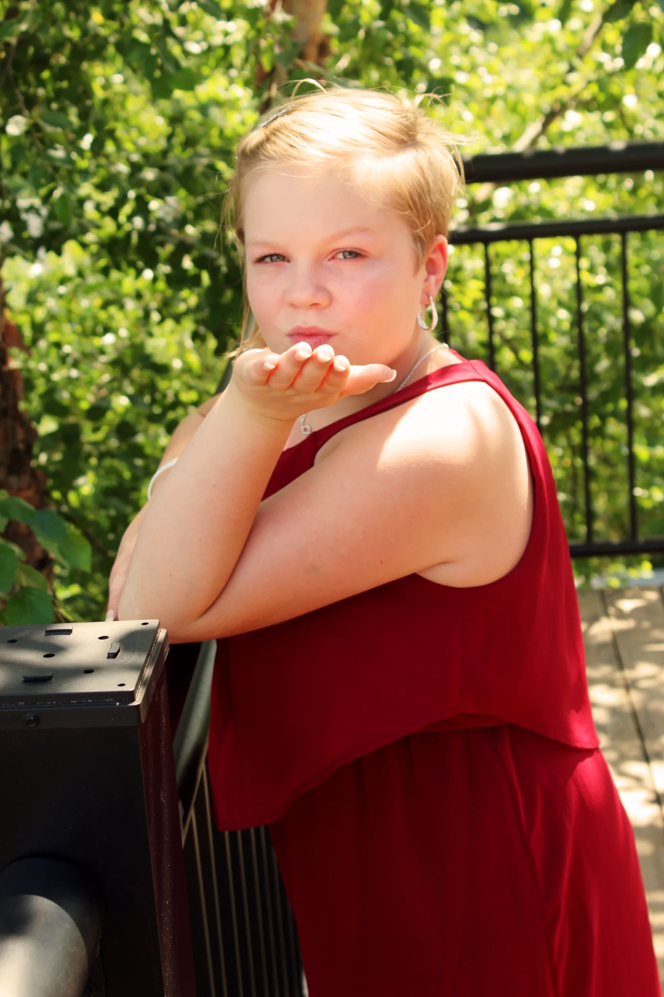 Wedding guest in red dress blowing a kiss on a deck at Moose Hollow Lodge in Pigeon Forge near Smoky Mountains
