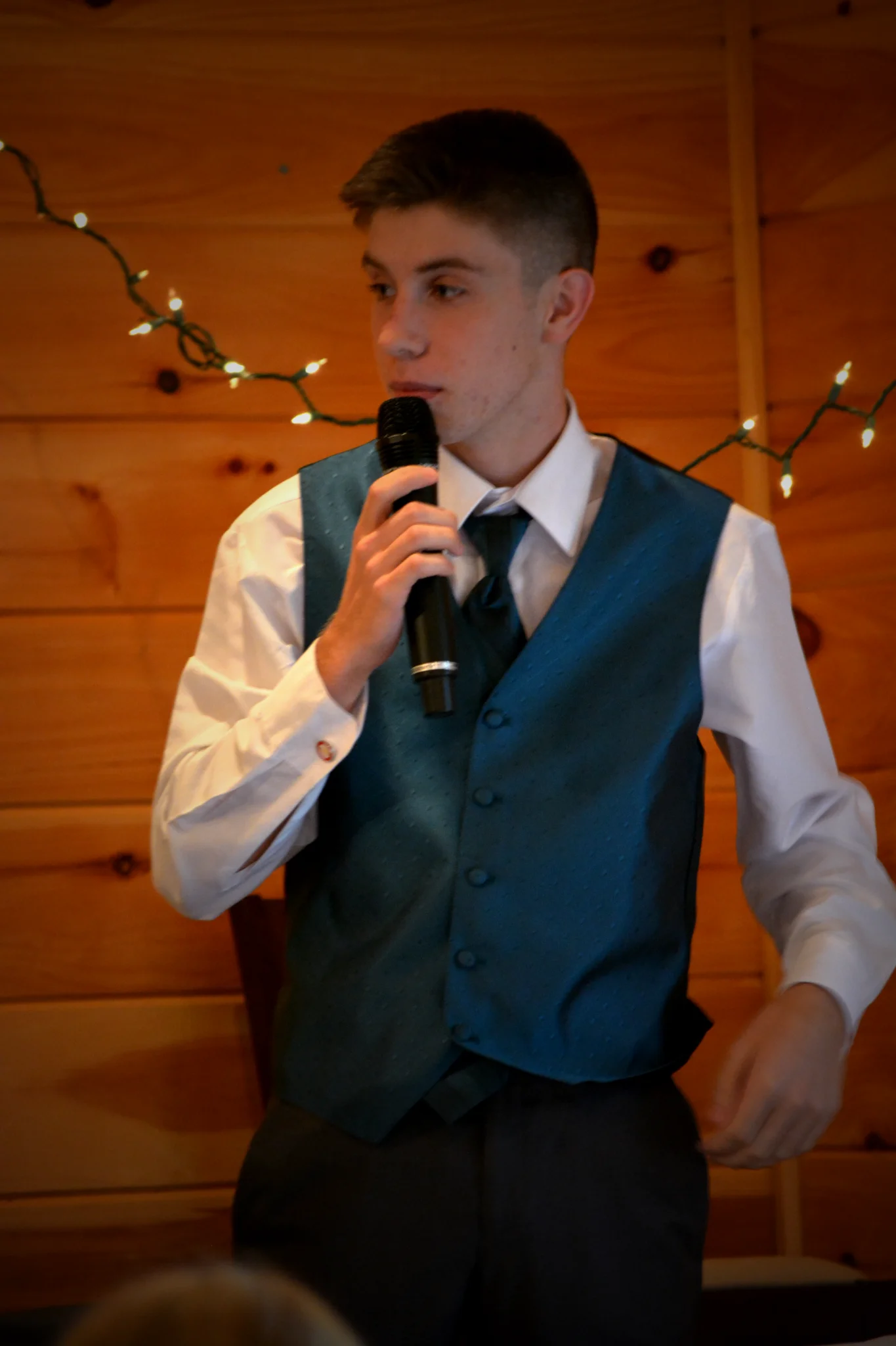 Wedding toast with a microphone against rustic wood walls at Moose Hollow Lodge in Pigeon Forge