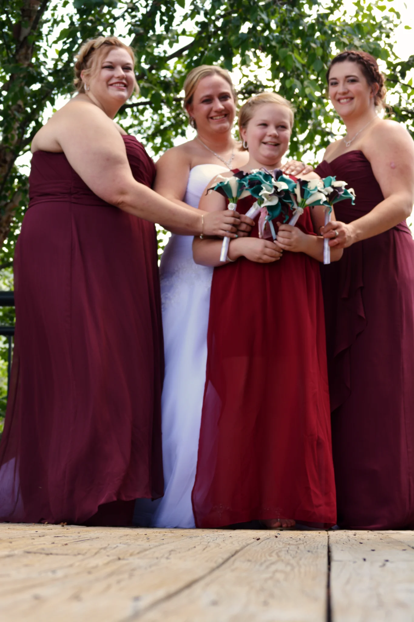 Bride and bridesmaids in burgundy dresses on outdoor deck at Moose Hollow Lodge near Smoky Mountains in Pigeon Forge