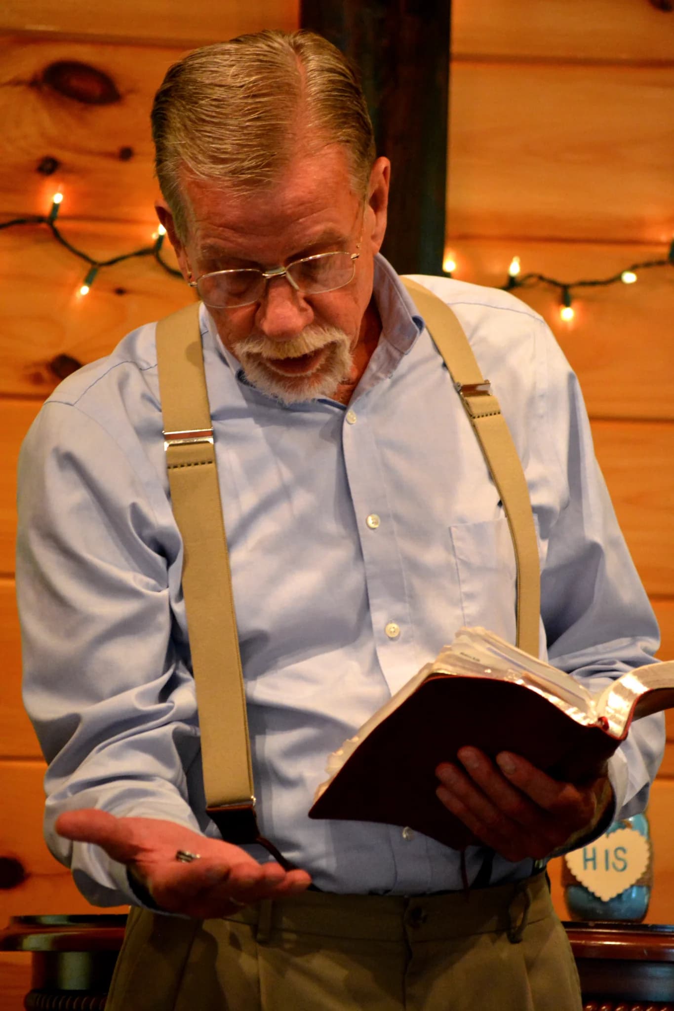 Wedding officiant holding rings and Bible against rustic wood walls at Moose Hollow Lodge in Pigeon Forge