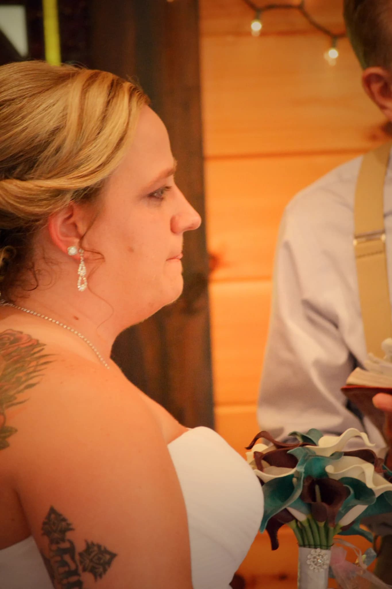 Bride with teal bouquet at a rustic indoor wedding ceremony at Moose Hollow Lodge in Pigeon Forge