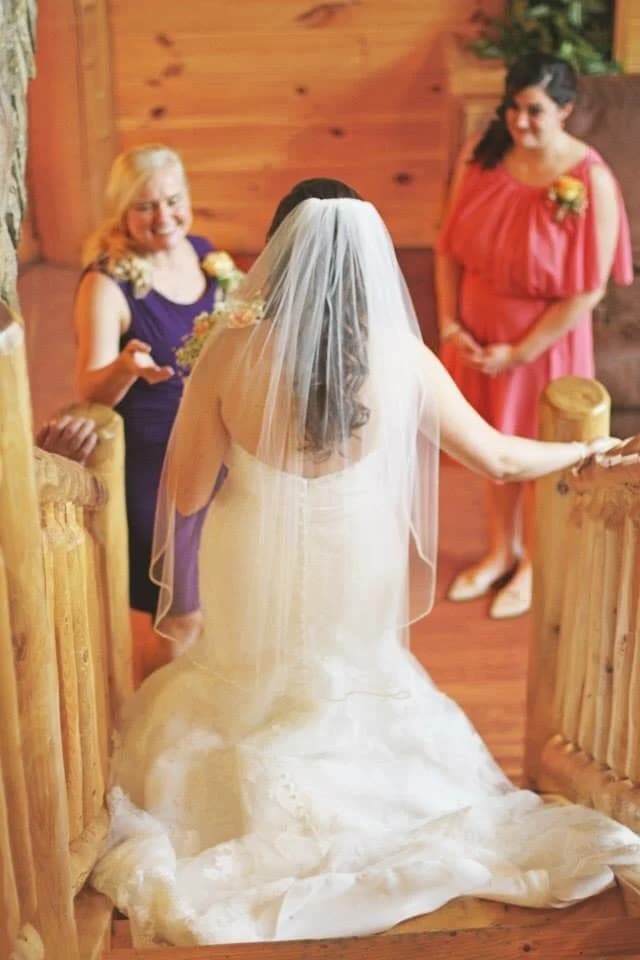 Bride descending rustic log staircase for a wedding ceremony at Moose Hollow Lodge in Pigeon Forge