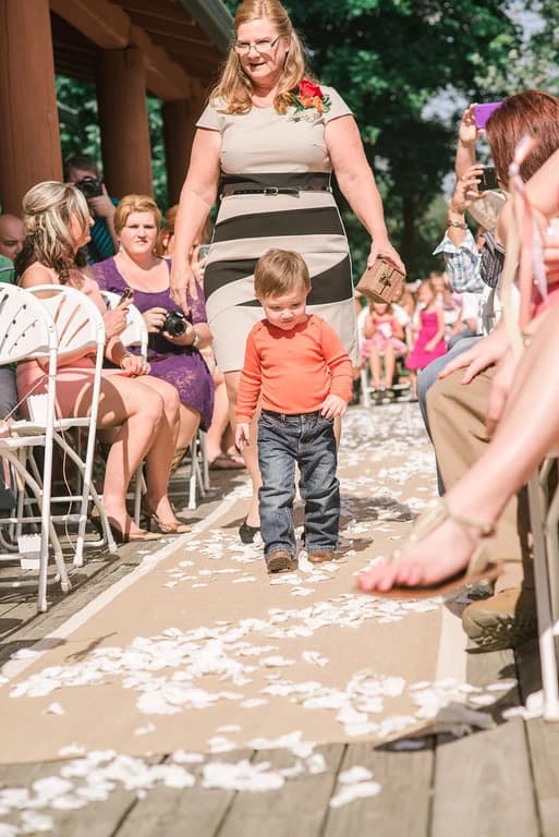 Outdoor wedding ceremony with ring bearer on petal-covered aisle at Moose Hollow Lodge in Pigeon Forge near Dollywood