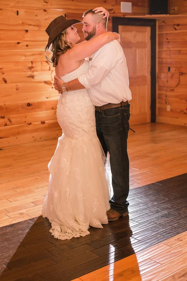 Bride and groom dancing in rustic wood-paneled reception hall at Moose Hollow Lodge in Pigeon Forge