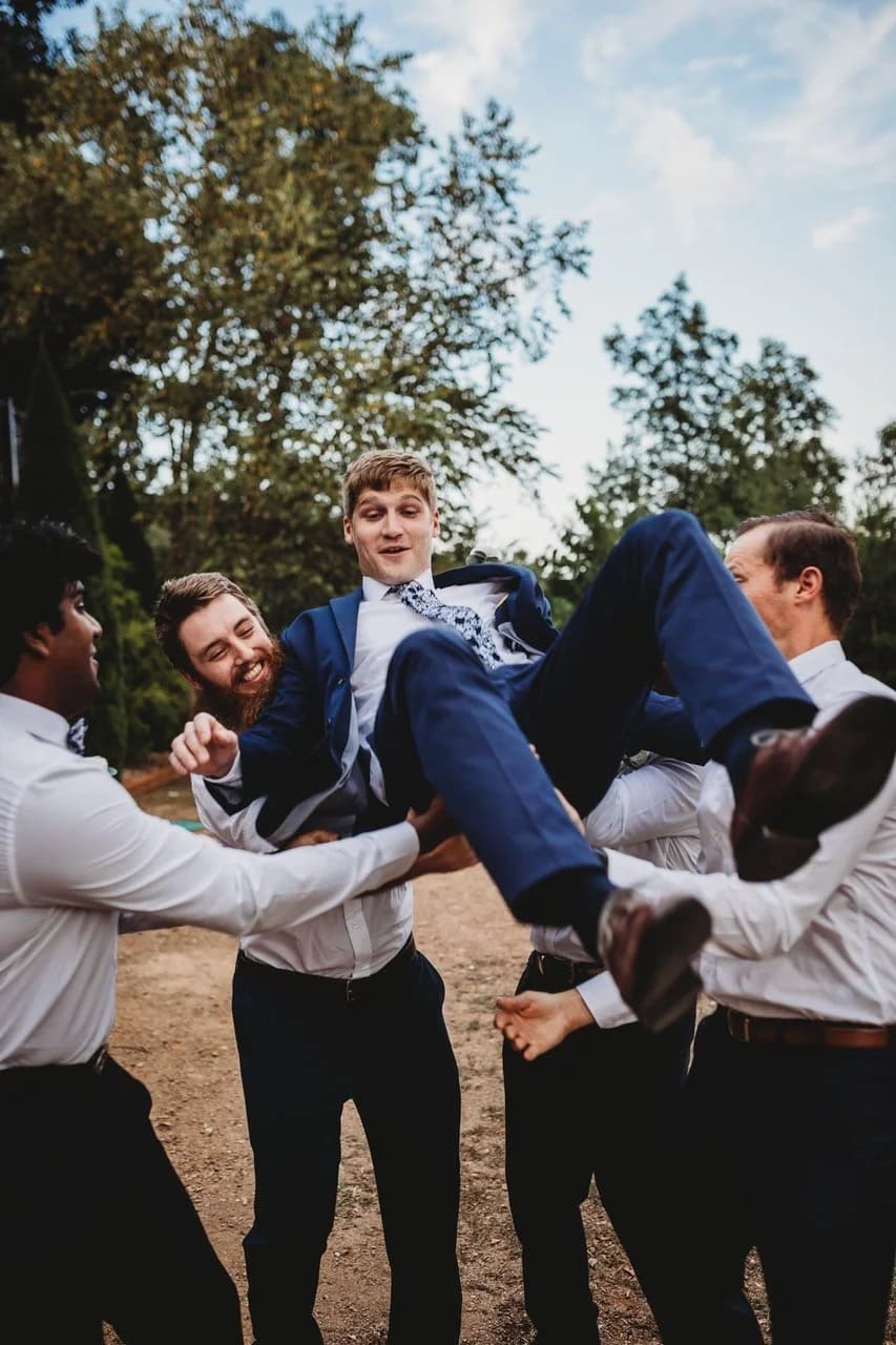 Groomsmen lifting the groom outdoors at Moose Hollow Lodge in Pigeon Forge near the Smoky Mountains