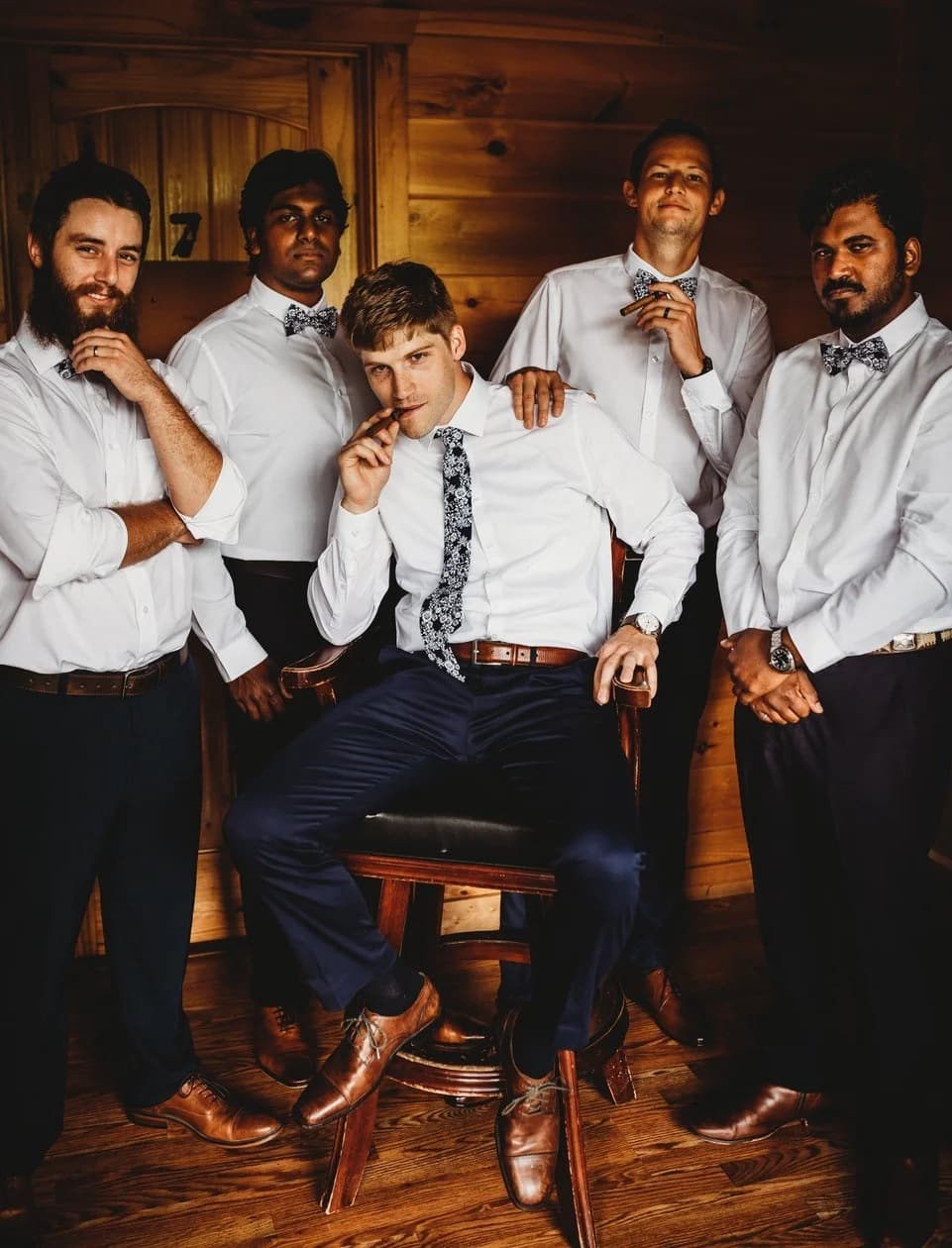 Groomsmen posing in rustic wood-paneled wedding suite at Moose Hollow Lodge in Pigeon Forge