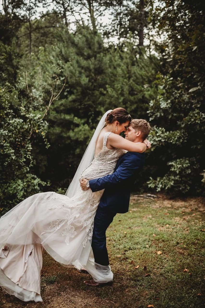 Groom lifting bride in forest setting for Great Smoky Mountains wedding near Dollywood at Moose Hollow Lodge in Pigeon Forge