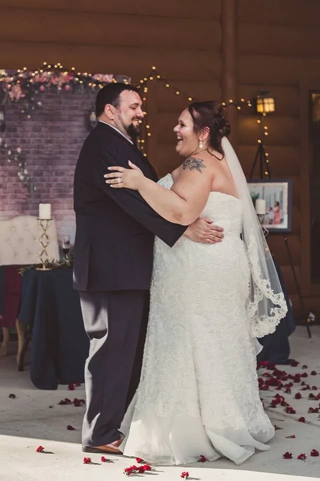 Newlyweds dancing on a rose petal floor in a rustic wedding venue at Moose Hollow Lodge in Pigeon Forge