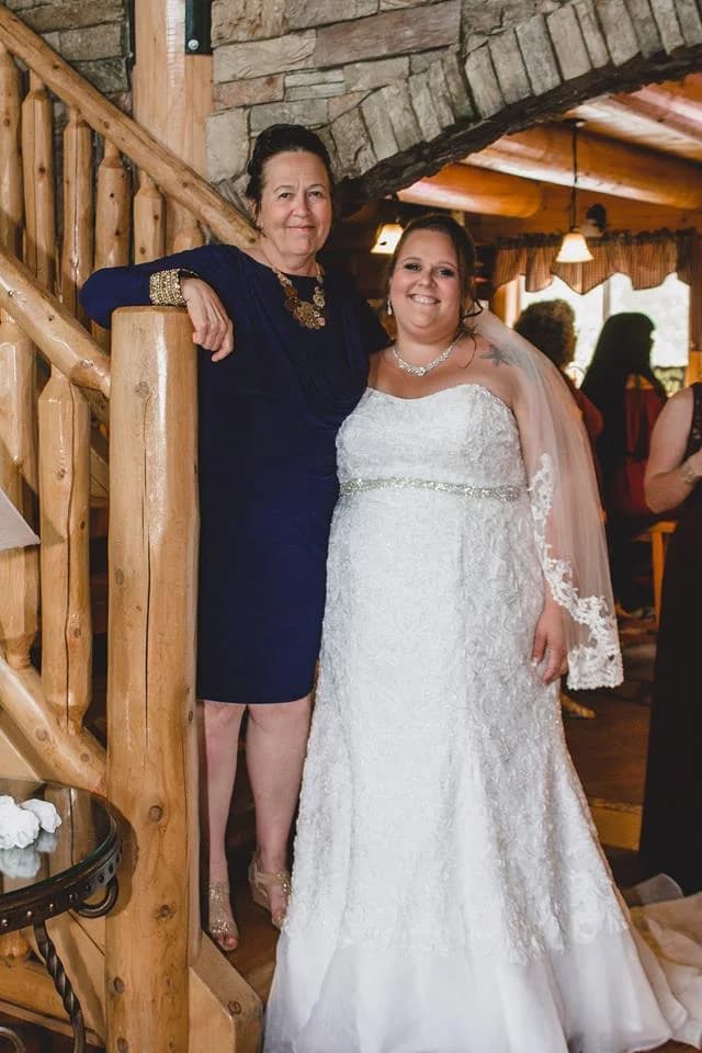 Bride posing by rustic log staircase and stone arch inside Moose Hollow Lodge in Pigeon Forge