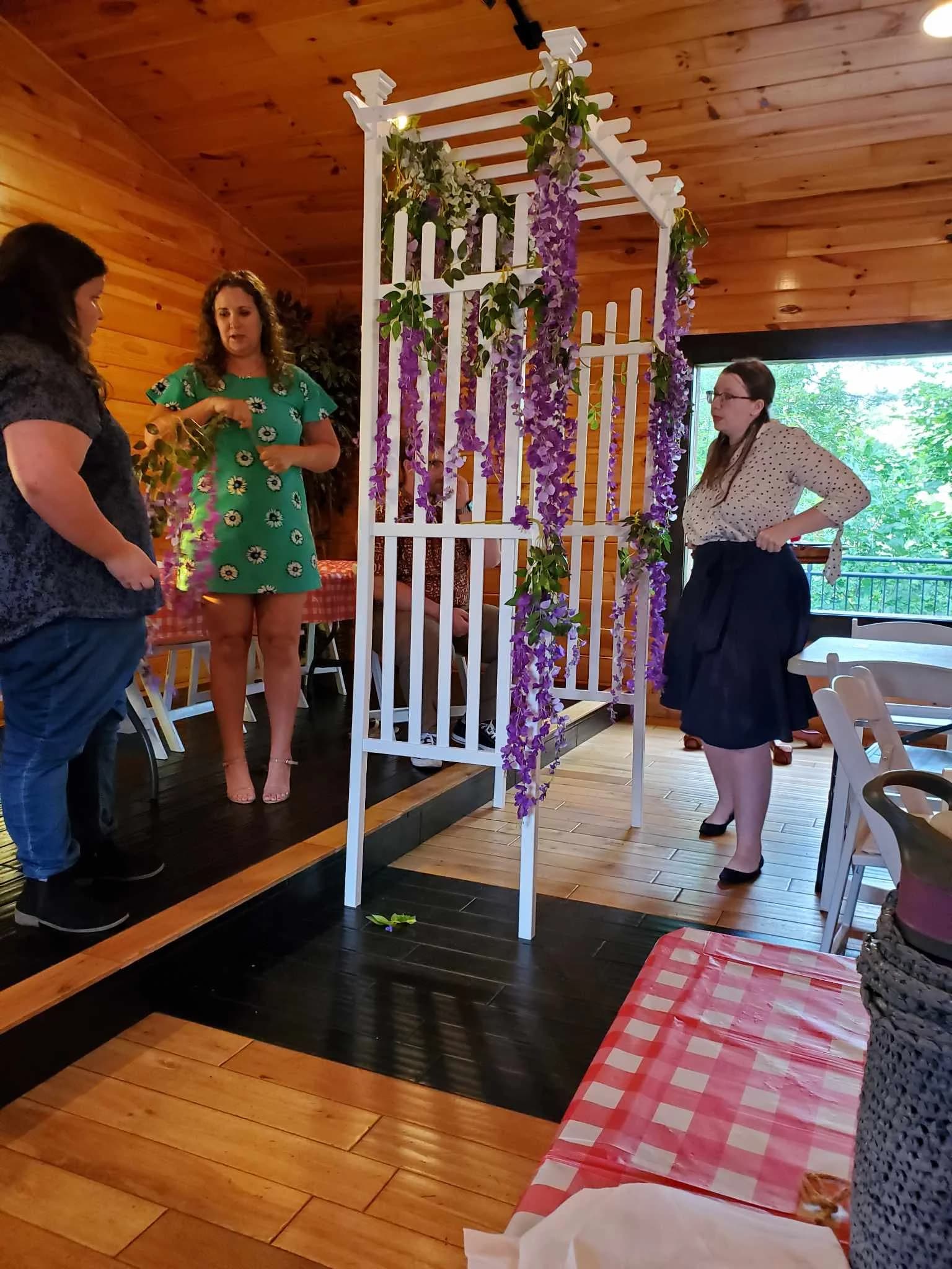 Indoor wedding reception space with white floral arbor and wood walls at Moose Hollow Lodge in Pigeon Forge