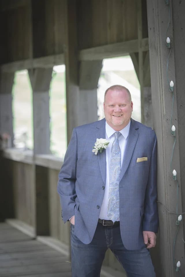 Groom in blue suit at rustic outdoor wedding venue near Dollywood at Moose Hollow Lodge in Pigeon Forge