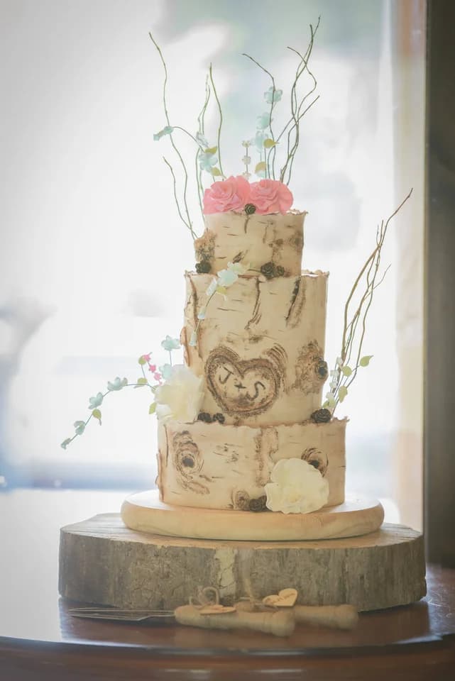 Rustic three-tier birch log wedding cake with floral accents at Moose Hollow Lodge in Pigeon Forge