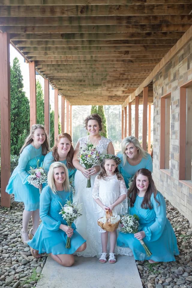 Bride and bridesmaids posing under rustic wood deck at Moose Hollow Lodge in Pigeon Forge near Smoky Mountains