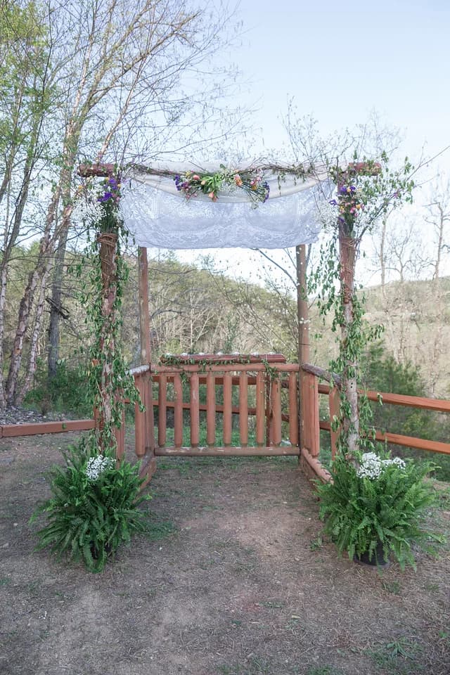 Rustic log wedding arbor with white lace canopy at Moose Hollow Lodge near Dollywood in the Smoky Mountains