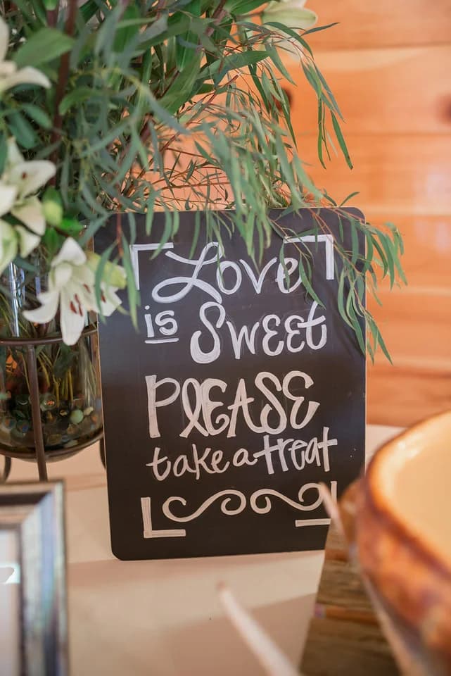 Rustic "Love is Sweet" wedding sign and white lilies at Moose Hollow Lodge in Pigeon Forge