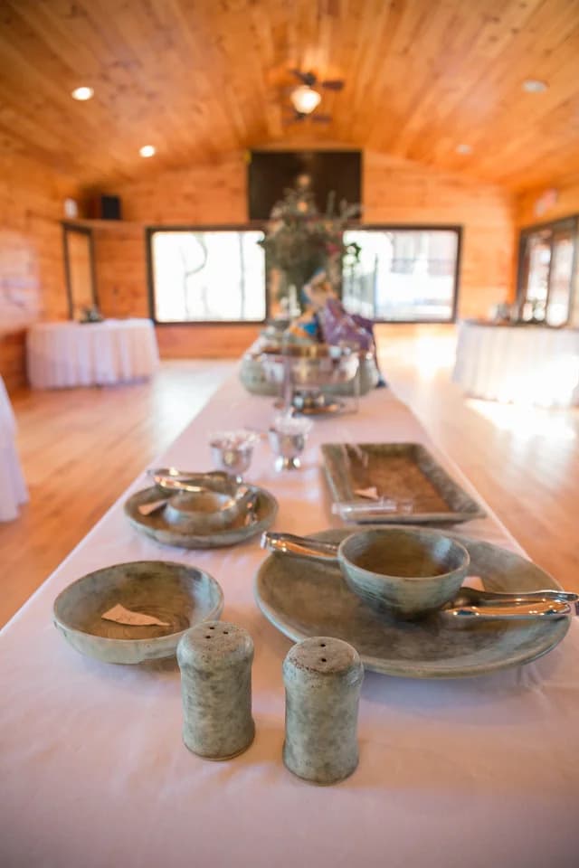 Rustic stoneware dishes on buffet table in wood-paneled event hall at Moose Hollow Lodge in Pigeon Forge.