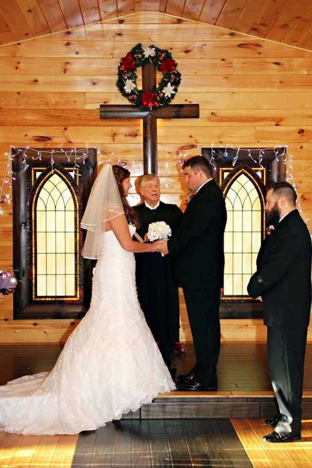 Wedding ceremony in rustic chapel with wooden cross and stained glass at Moose Hollow Lodge in Pigeon Forge