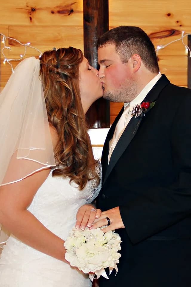 Bride and groom kissing in rustic wedding venue at Moose Hollow Lodge in Pigeon Forge