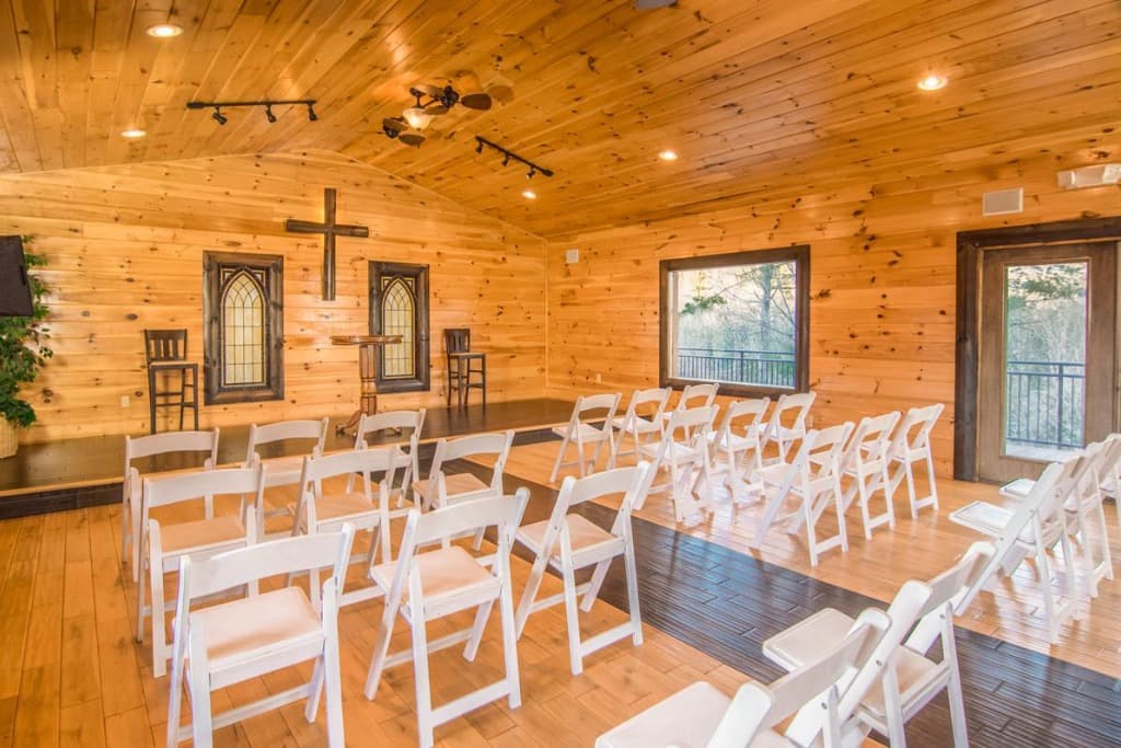 Rustic wedding chapel with rows of white chairs and wood paneling at Moose Hollow Lodge in Sevierville